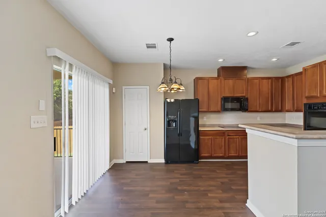 a view of a hallway with wooden floor and chandelier