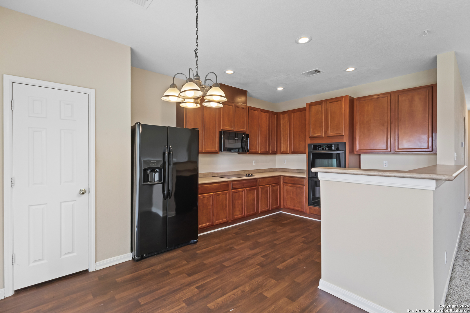 156 Springtree Bluff Cibolo, TX 78108 - Photo 19 of 42 a kitchen with stainless steel appliances granite countertop a refrigerator a sink dishwasher a oven and a dining table with wooden floor