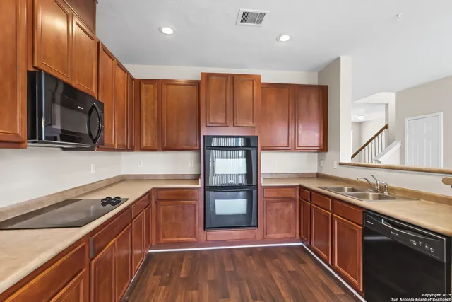 a kitchen with granite countertop wooden cabinets and stainless steel appliances