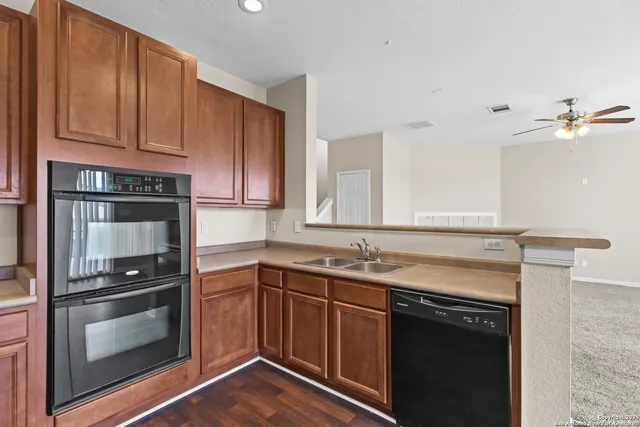 a kitchen with a sink and wooden floor