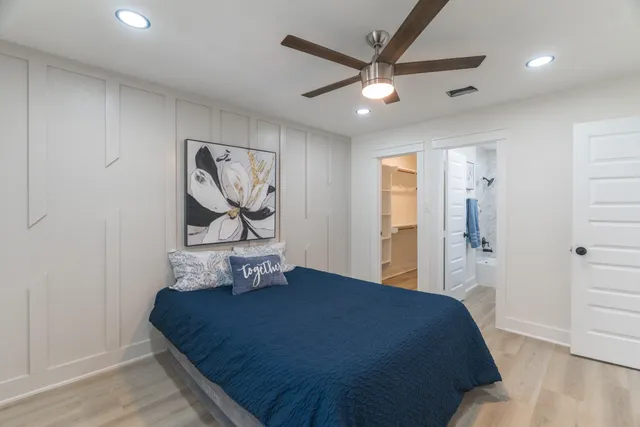 a bedroom with a bed and a painting on the wall