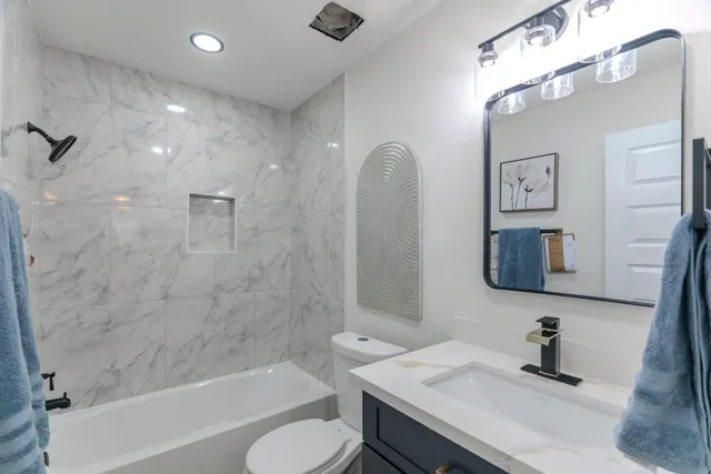 a bathroom with a sink a toilet and shower