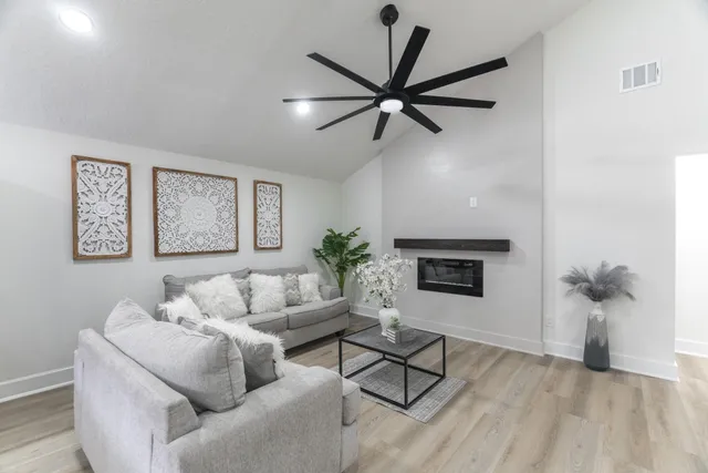 a living room with furniture and a wooden floor
