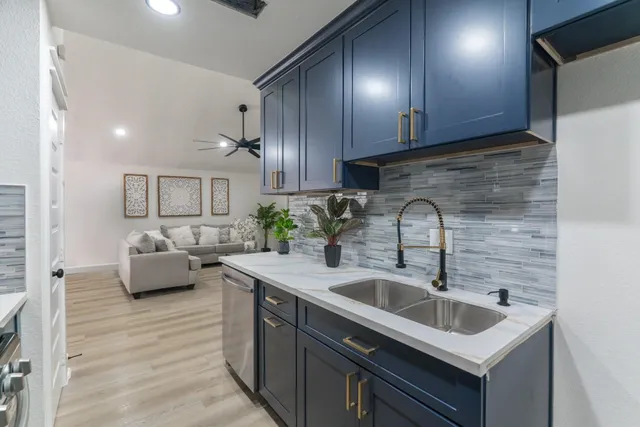 a kitchen with a sink cabinets and living room