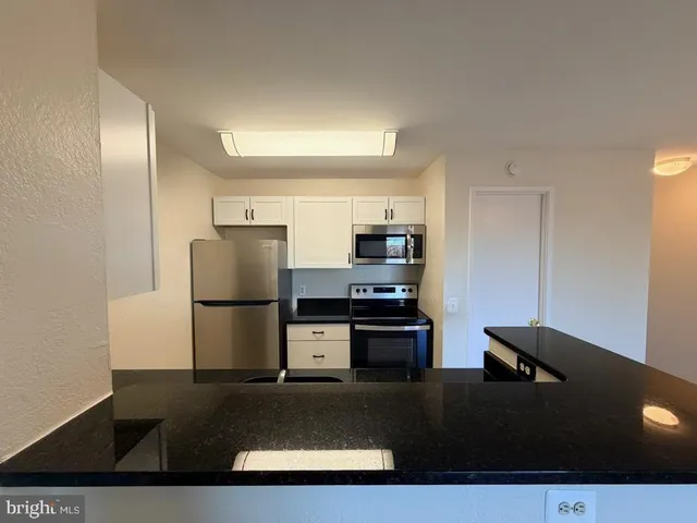 a kitchen with stainless steel appliances a refrigerator sink and stove