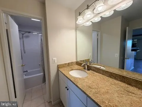 a bathroom with a granite countertop sink a light fixture and a mirror