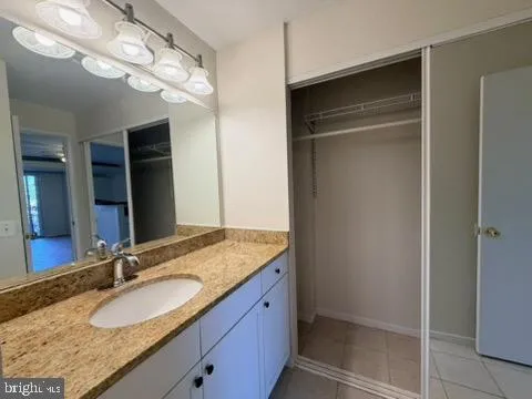 a bathroom with a granite countertop sink and a mirror
