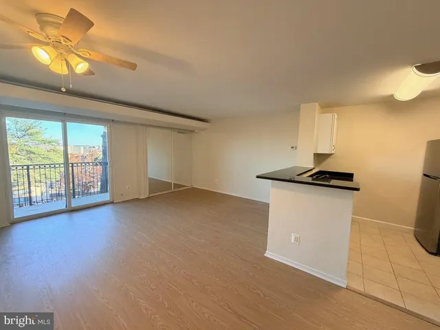 a view of empty room with a window and wooden floor