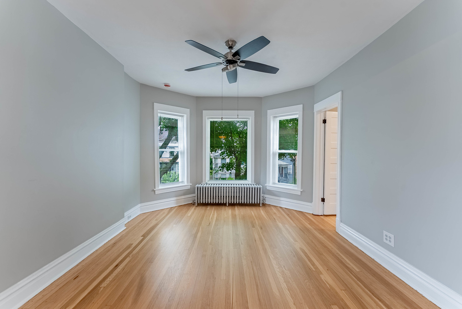 4730 West Warwick Avenue, Unit 2 Chicago, IL 60641 - Photo 4 of 26 a view of a livingroom with wooden floor a ceiling fan and windows