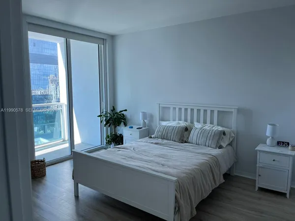 a bedroom with a large bed and a potted plant