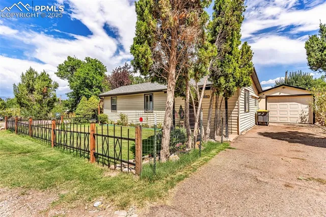 a view of a house with a small yard and wooden fence