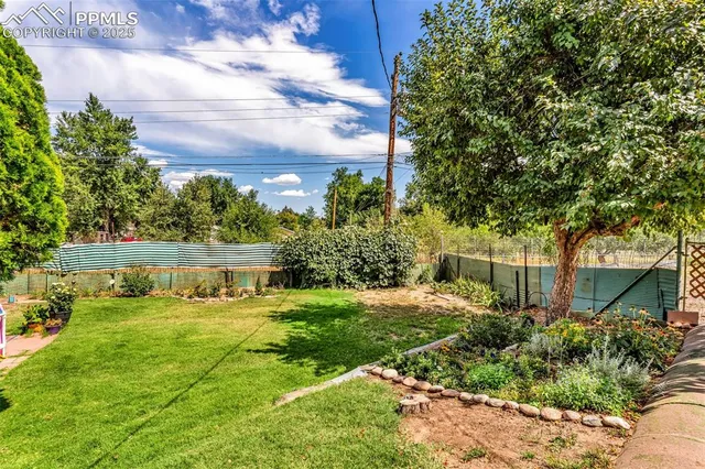 a view of a house with garden and trees