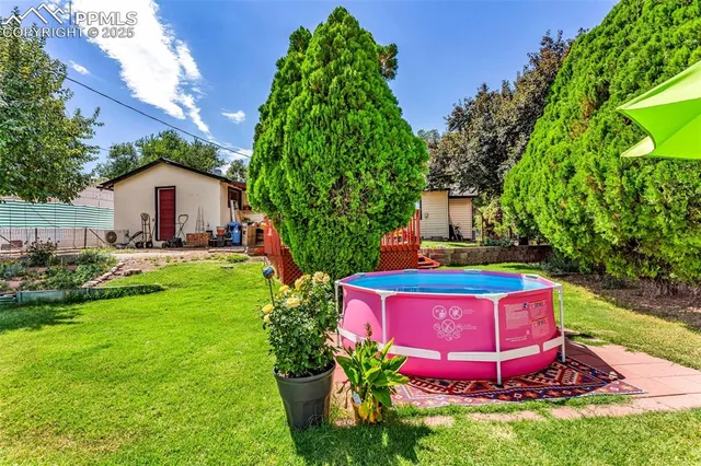 a view of a house with a yard and potted plants