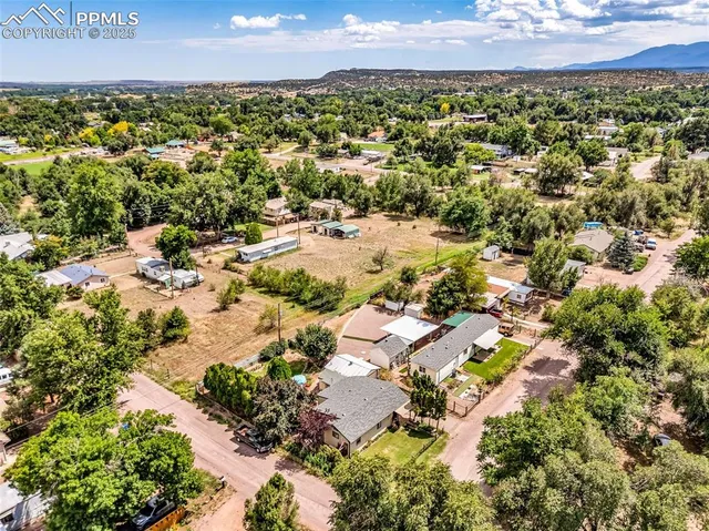 an aerial view of residential houses with outdoor space and trees