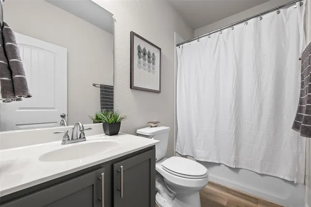 a bathroom with a granite countertop sink and a toilet