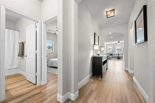 a view of a hallway view with wooden floor and living room