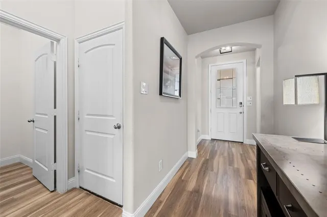 a view of a hallway with wooden floor and staircase