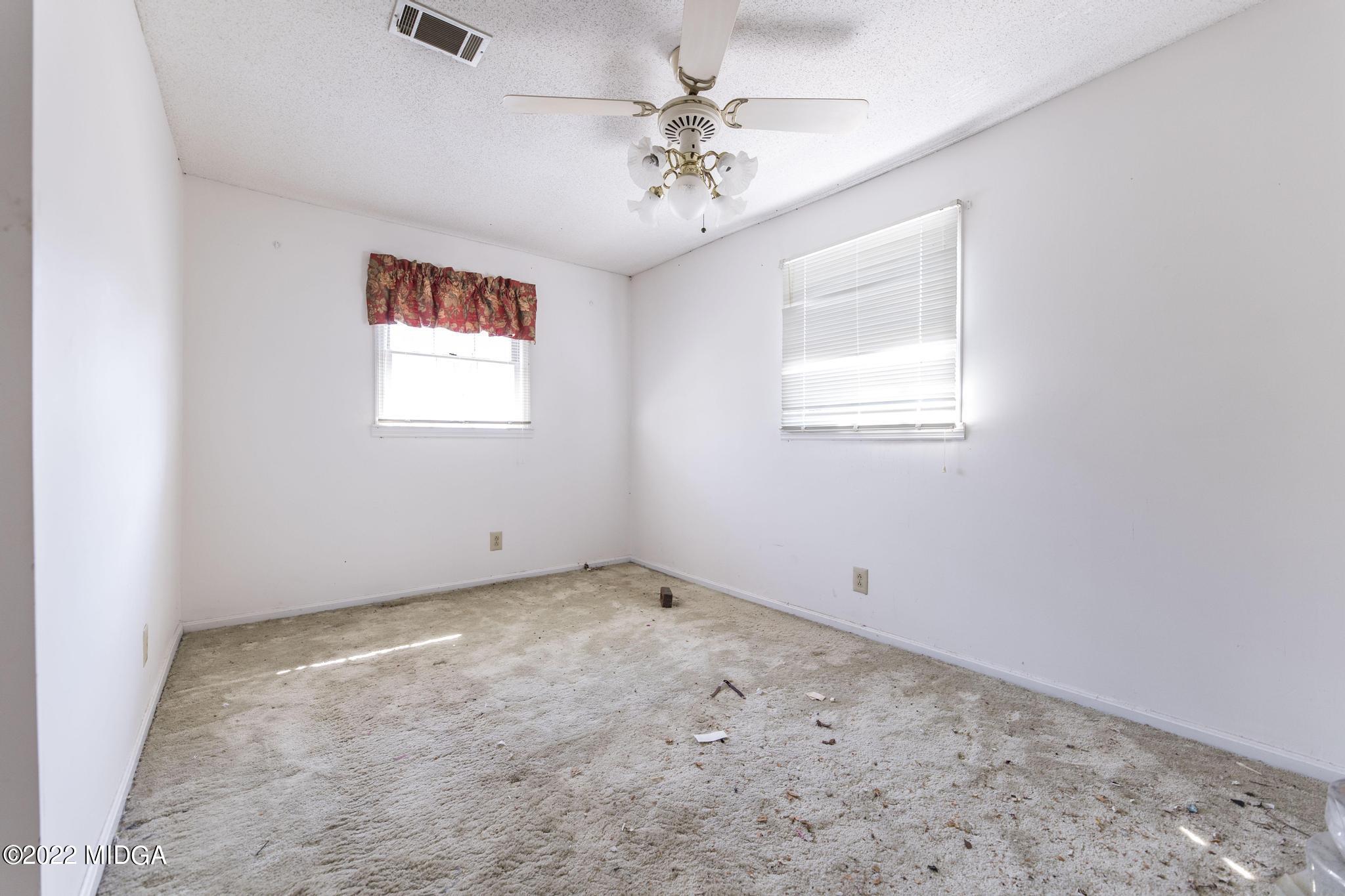 10 Mattie Road Fort Valley, GA 31030 - Photo 34 of 48 an empty room with a chandelier fan and windows