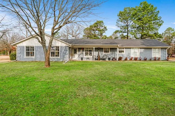 a front view of a house with a garden and trees