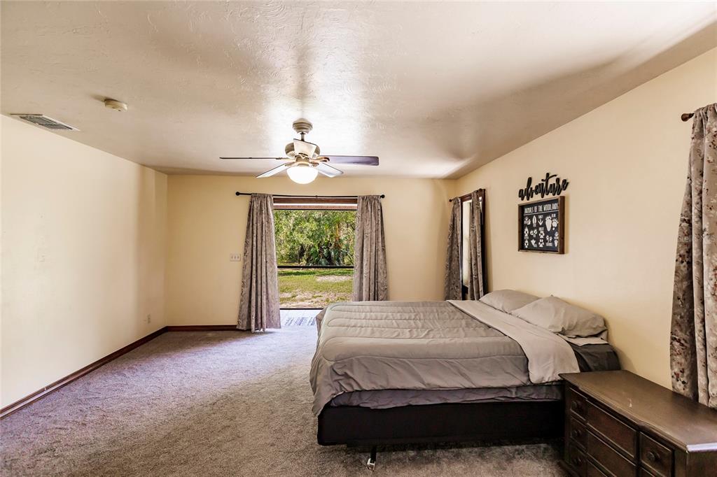 5826 Highway 72 Arcadia, FL 34266 - Photo 27 of 62 a spacious bedroom with a bed and a chandelier