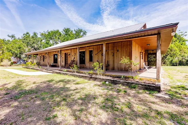 a view of a house with backyard and porch