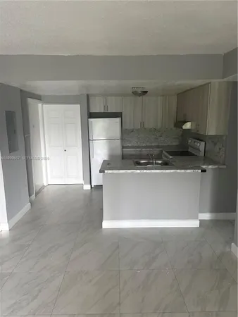 a view of kitchen with white cabinets