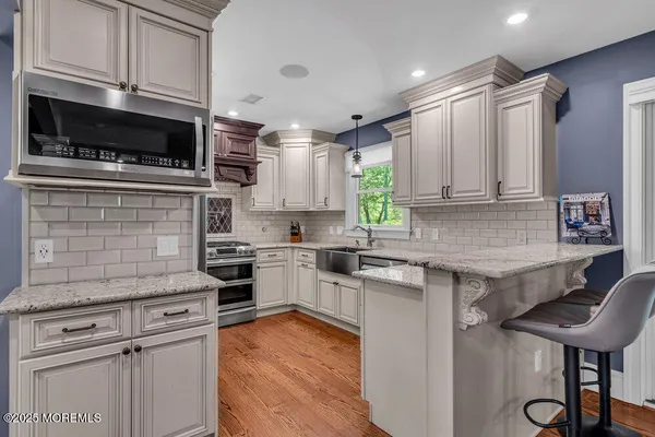 a kitchen with cabinets wooden floor and a window