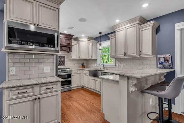 a kitchen with cabinets wooden floor and a window