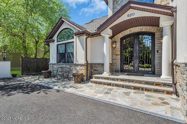 a view of staircase with lots of frames on wall and a dining table