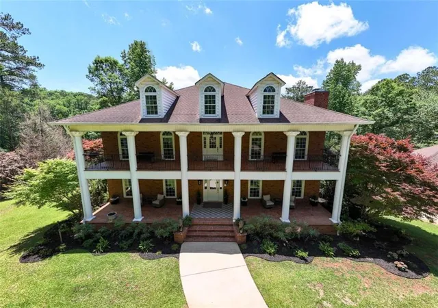 a front view of a house with a yard and potted plants