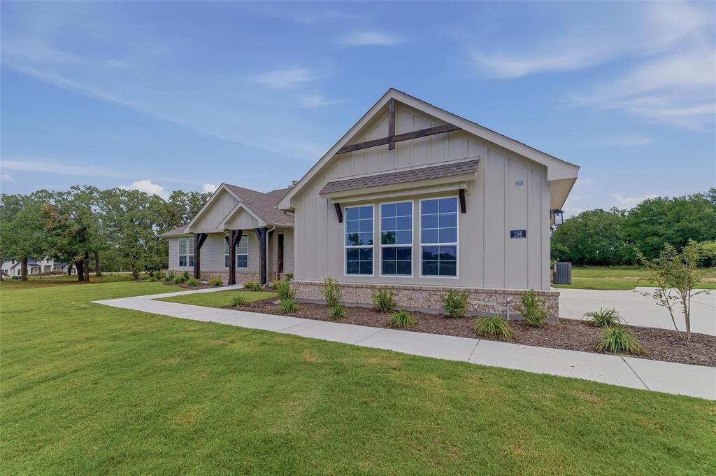 156 Oak Grv Way Springtown, TX 76082 - Photo 3 of 25 Board and batten siding exterior with a stone accent foundation, multiple gables, a covered front porch with dark wood pillars, and a concrete driveway