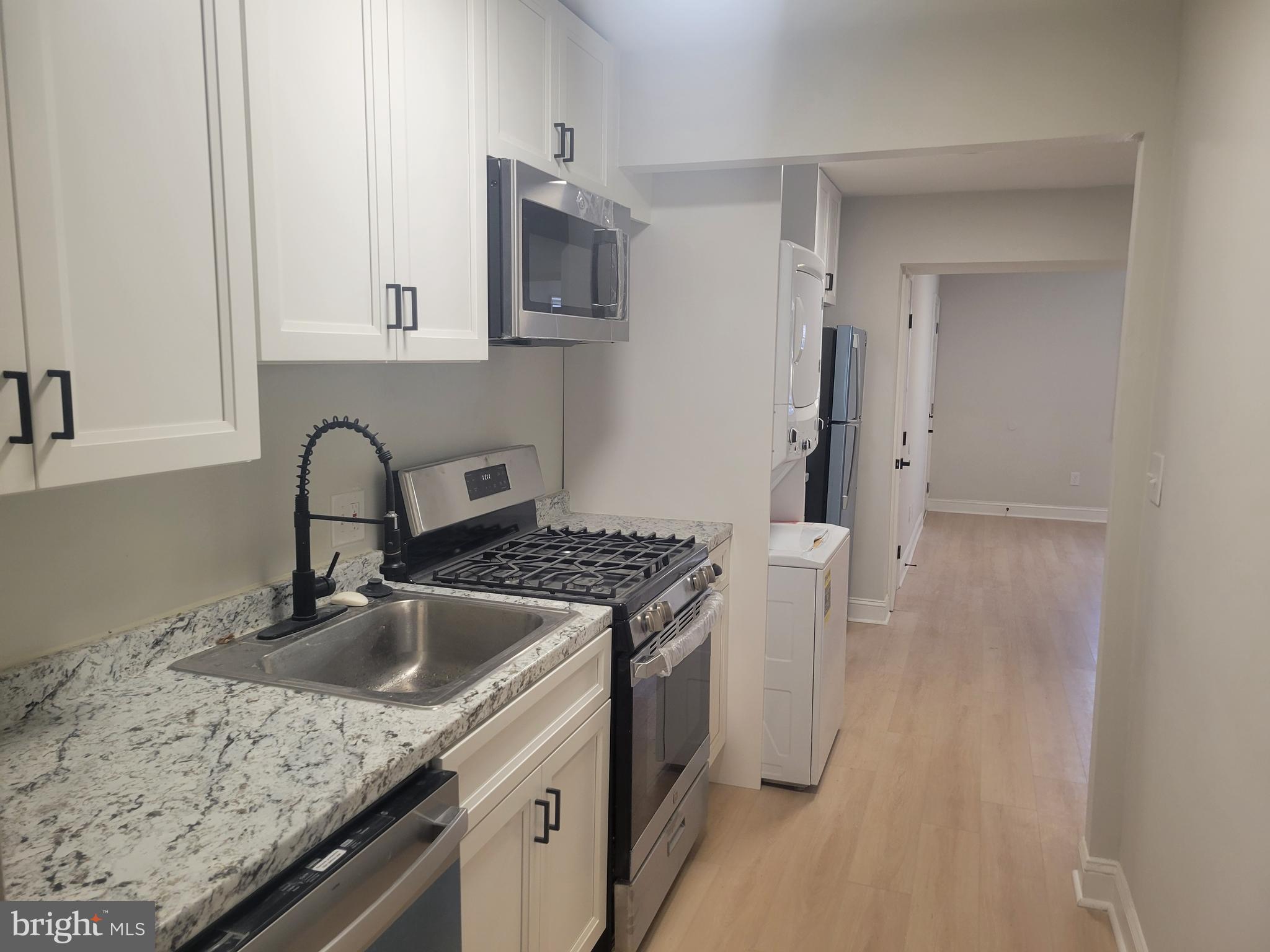 1250 Queen Street Northeast, Unit 1 Washington, DC 20002 - Photo 12 of 13 a kitchen with a sink stove and cabinets