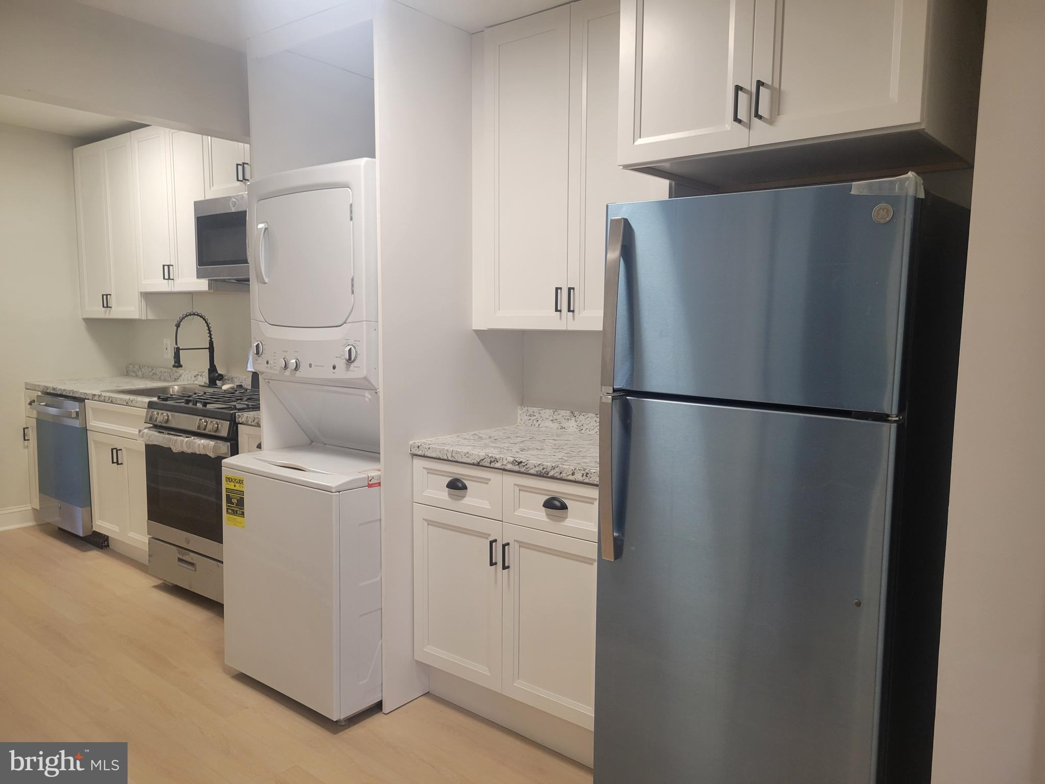 1250 Queen Street Northeast, Unit 1 Washington, DC 20002 - Photo 10 of 13 a kitchen with white cabinets and white appliances