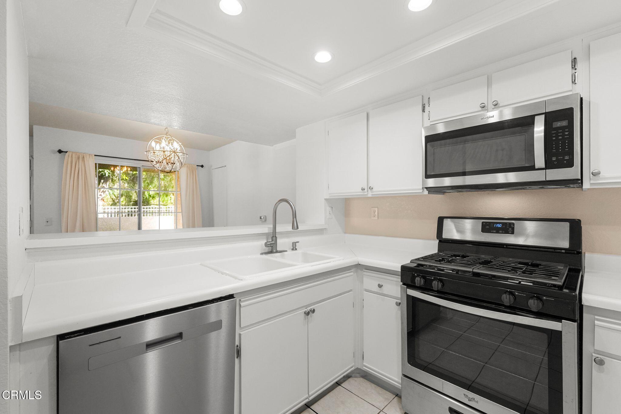 1195 Fitzgerald Road, Unit C Simi Valley, CA 93065 - Photo 15 of 26 a kitchen with stainless steel appliances granite countertop a sink stove a microwave and cabinets