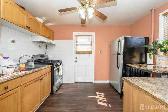 a kitchen with stainless steel appliances granite countertop a refrigerator a stove and a sink