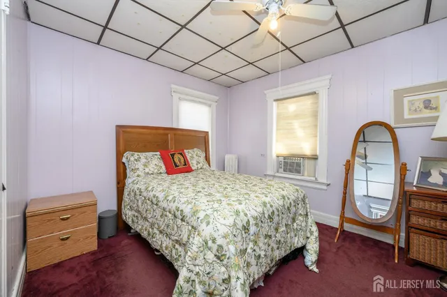 a bedroom with a bed and a dresser next to a window