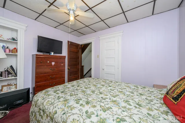 a bedroom with a bed and a flat tv screen on dresser