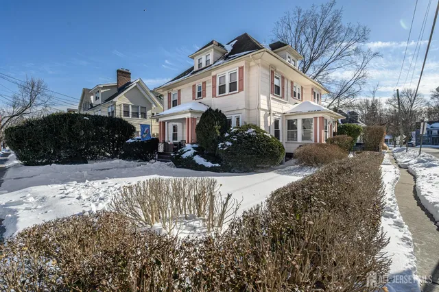 a front view of a house with a yard covered with snow