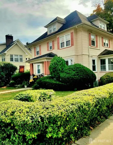 a front view of a house with a yard and potted plants