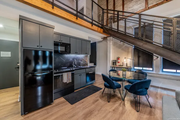a kitchen with granite countertop a refrigerator and a stove top oven