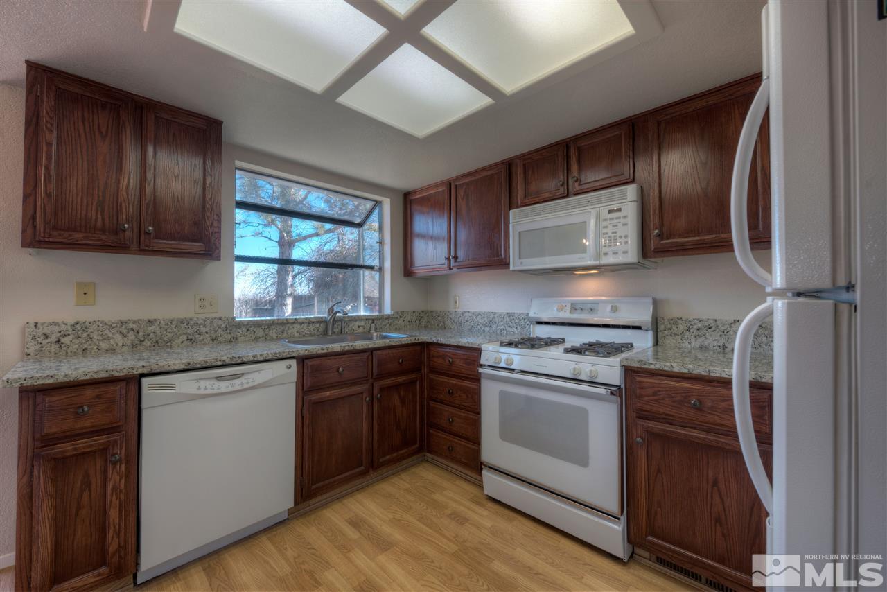 1800 Amarak Way Reno, NV 89523 - Photo 8 of 25 a kitchen with stainless steel appliances granite countertop wooden cabinets stove top oven and sink