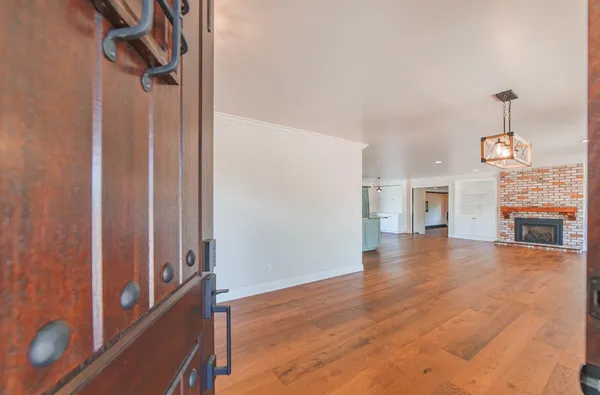 a view of a living room and kitchen with furniture wooden floor and windows