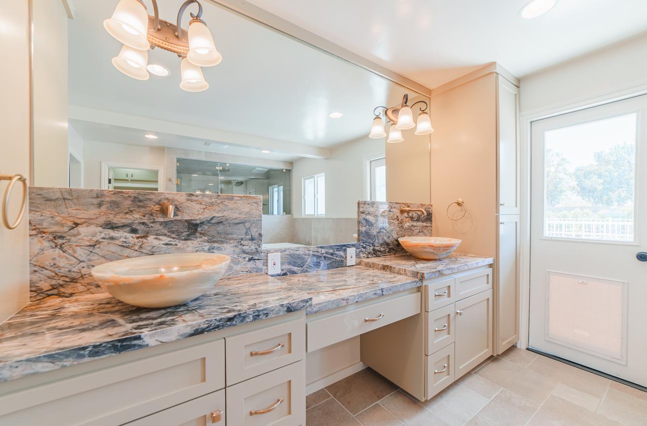 22125 Ranchito Drive Salinas, CA 93908 - Photo 33 of 66 a bathroom with a granite countertop sink a large mirror and vanity
