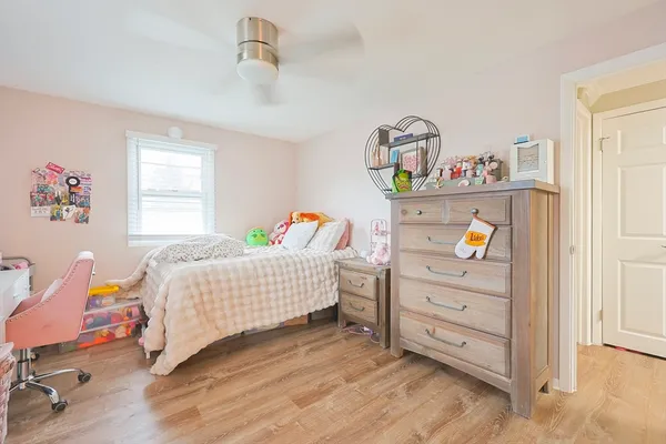 a bedroom with a bed and wooden floor