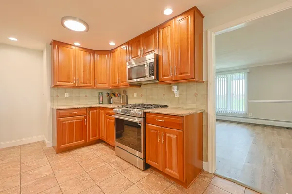 a kitchen with stainless steel appliances granite countertop a stove a sink and a refrigerator