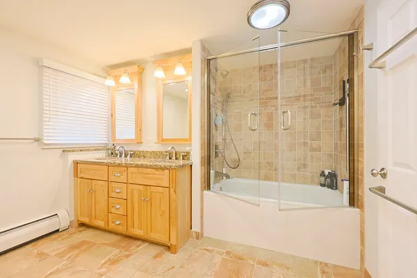 a bathroom with a granite countertop sink a mirror and a bathtub