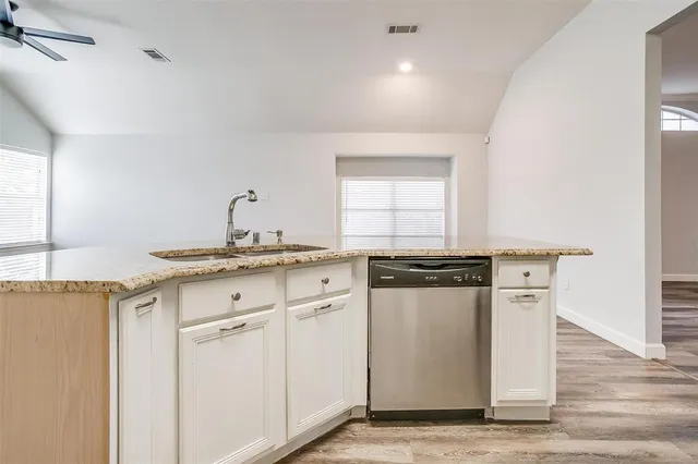a kitchen with granite countertop white cabinets and white appliances