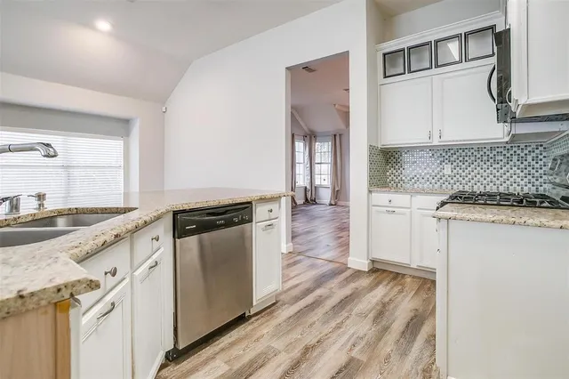 a kitchen with granite countertop cabinets stainless steel appliances and wooden floor