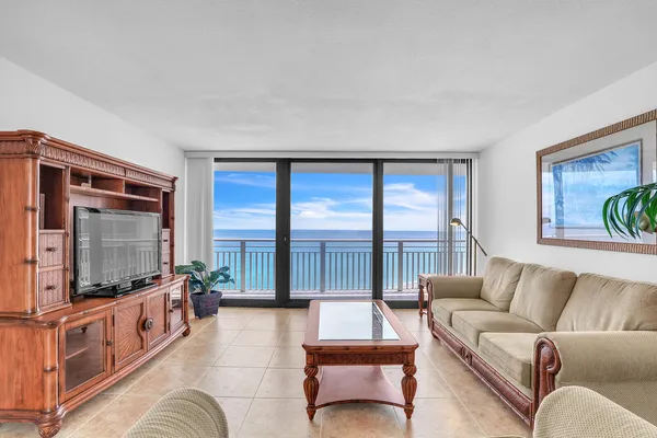 a living room with furniture a flat screen tv and a large window