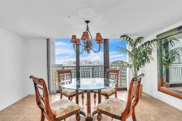 a dining room with furniture a rug and a potted plant